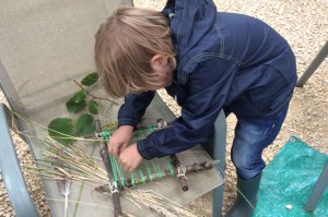 boy working on twig loom