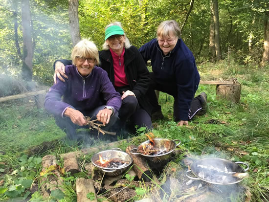 three women making a camp fire