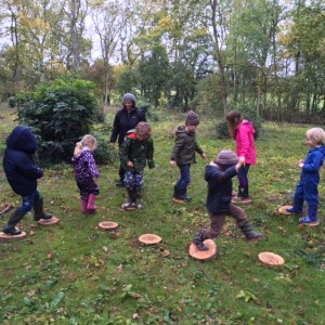 children jumping from one circle of wood to another