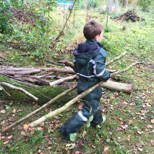 boy dragging logs