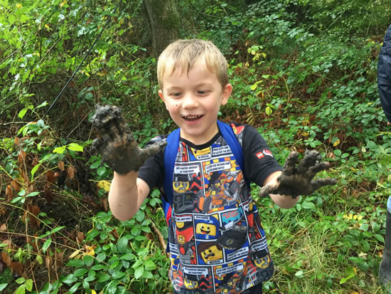 child with muddy hands