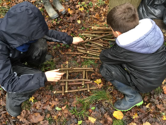 two people building stick tower