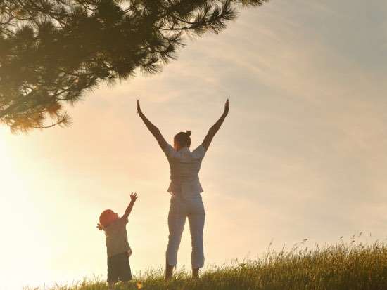 adult and child reaching upwards